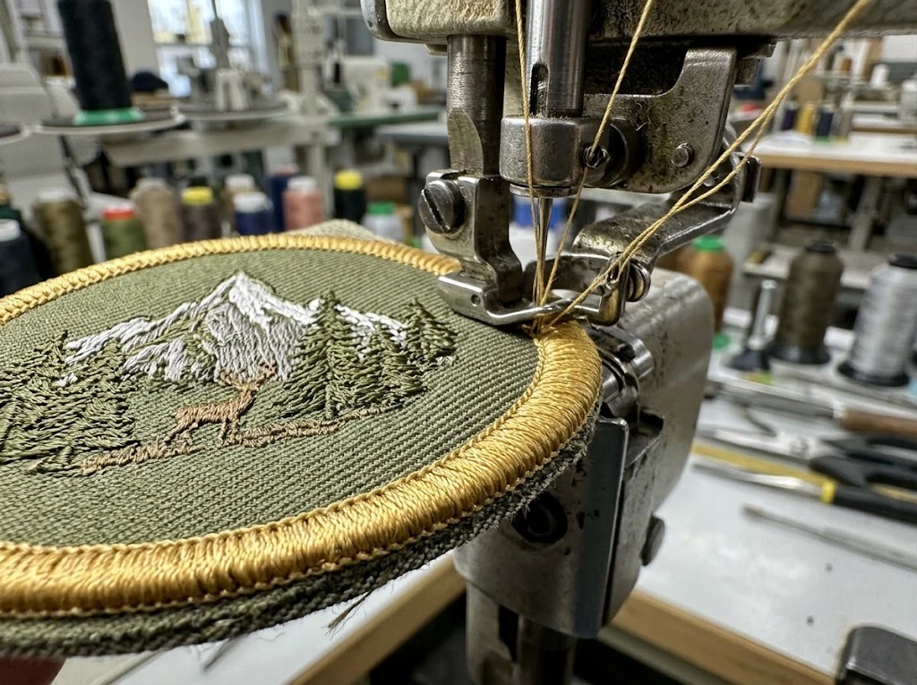 Merrowed border being applied to an embroidered patch edge
