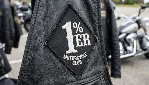 A biker vest with a 1% biker patch with a Harley-Davidson in the background.